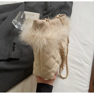 Detailed view of cream quilted tote bag with ostrich feather trim and gold chain strap