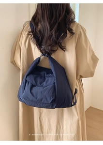 Close-up of a navy blue quilted puffer bag with soft nylon texture and flap closure