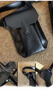 Detail view of adjustable strap and snap closure on the black textured leather bag