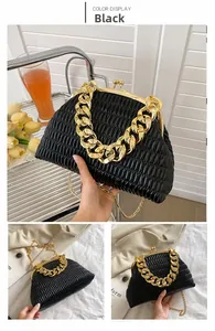 Detail of black pleated cloud bag featuring gold chain handle and vintage metal closure