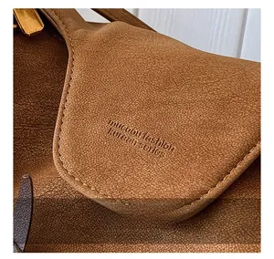 Macro shot of brown pebble grain leather surface with embossed logo and fine stitching