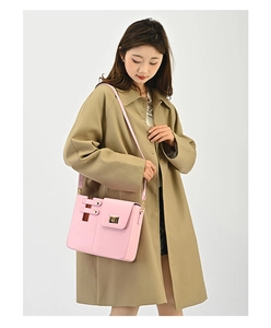 Detailansicht der rosa Leder-Flaschentasche mit goldenem Drehverschluss auf Trenchcoat