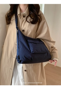 Détail du grand sac cabas plissé bleu marine sur un mannequin avec une touche rétro chic