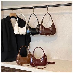 Detail of diverse crescent bags in patent leather with gold chain and thin shoulder straps