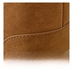 Detail of premium brown suede leather with precise double-stitching on a stylish pillow bag
