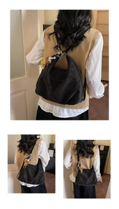 Detail of a black hobo bag in matte leather featuring a cute bear pendant on the side