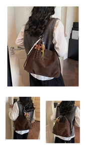 Detail view of a vintage brown leather tote bag with cute star and bear charms