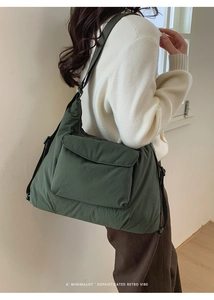 Detail of dark green waterproof nylon tote bag with large front flap pocket and strap