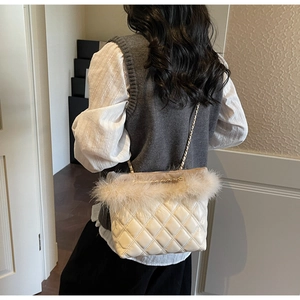 Detail of beige quilted shoulder bag with ostrich feather trim and gold chain strap