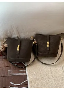 Détails des sacs seaux marron foncé avec fermoirs dorés et charmant pendentif ours peluche