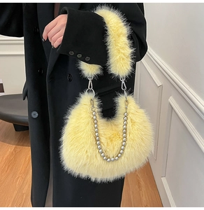 Détail d'un sac à main en peluche jaune avec une chaîne décorative à perles argentées
