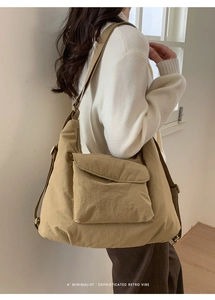 Khaki large capacity canvas tote bag with front pocket shown on shoulder by model