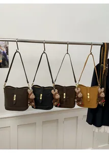 Détail de quatre sacs seaux vintage en cuir marron et noir avec breloques chien