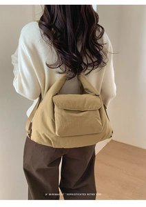Détail de la texture d'un grand sac cabas en nylon moutarde porté par un mannequin