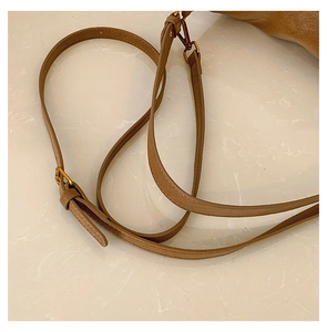 Detailed view of brown lychee grain leather shoulder strap with gold metal lobster clasp