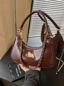 Retro dark brown glossy hobo bag with a stylish chain strap for women in a lifestyle view