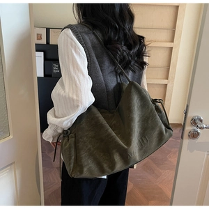 Detail view of the vintage olive green tote bag showing smooth matte texture and drawstrings