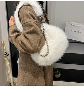 Détail d'un sac à bandoulière en peluche blanche avec chaîne à billes argentées