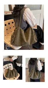 Detail of olive green suede tote bag with letter embossing and side drawstring closure