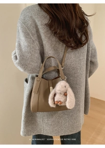 Brown textured leather crossbody bag with cute white plush rabbit charm detail