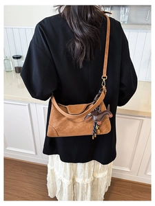 Detailed back view of brown leather pillow bag with dachshund charm and adjustable strap