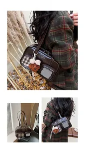 Détail du sac bandoulière marron foncé avec poche à carreaux et breloque ours en peluche