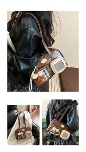 Détail d'un sac à bandoulière marron rétro avec multi-poches et breloque ourson