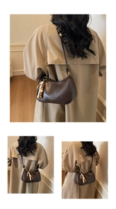 Detail of dark brown leather crescent bag with decorative beads and knot shoulder strap