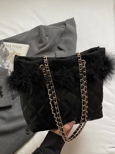 Black quilted leather shoulder bag with feather trim and gold chain strap in city style