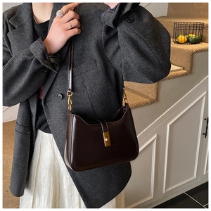 Dark brown patent leather underarm bag with gold rectangular metal turn-lock closure
