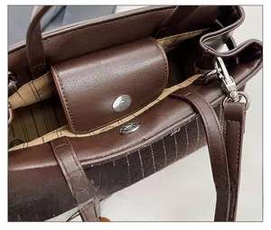 Detail view of the brown striped tote bag showing magnetic closure and interior lining