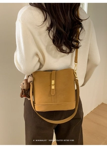 Détail du sac seau rétro jaune moutarde avec fermoir en métal et breloque ours en peluche