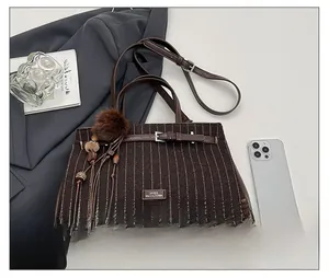 Detailed top view of striped wool tote bag with leather straps and plush charm