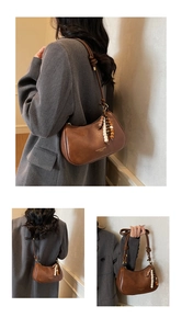 Detail of brown vintage crescent shoulder bag featuring wooden bead decorative accents