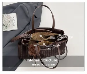 Detail view of striped tote interior with large compartment and zipper pockets