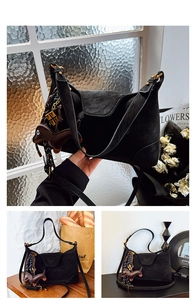 Detail of black matte shoulder bag with gold hardware and stylish dachshund charm