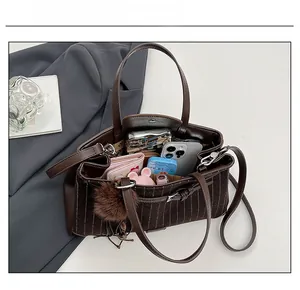 Detail view of large striped tote bag interior capacity with leather handle and charm