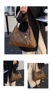 Detail of vintage brown quilted tote bag featuring a leather strap and smiley charm