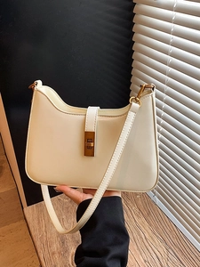 Chic cream underarm bag with gold buckle shown in a minimalist sunlit aesthetic