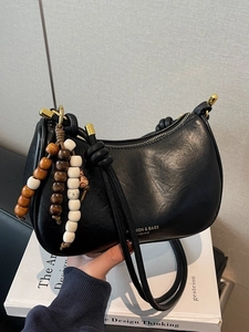 Retro black leather underarm bag with decorative wooden beads and gold logo detail