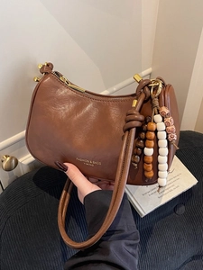 Vintage brown leather crescent underarm bag with decorative beaded strap detail