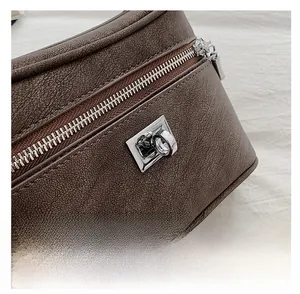 Détail d'un sac à main en cuir marron vintage avec fermoir rotatif carré et fermeture éclair