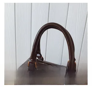 Detailansicht der dunkelbraunen Boston Tasche mit Griffen und goldfarbenen Metallschnallen