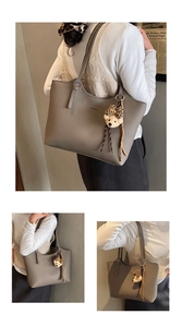 Detail view of grey faux leather tote bag with MOCOMU branding and cute bear charm