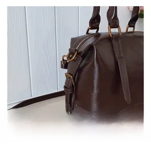 Detail einer dunkelbraunen Leder-Boston-Bag mit Vintage-Bronze-Beschlägen und Nähten