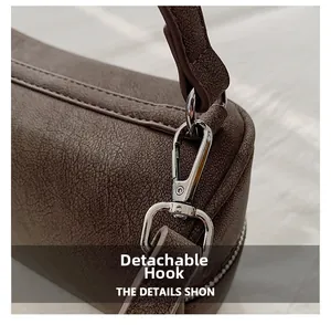 Détail du crochet métallique amovible argenté sur sac à main en cuir marron foncé