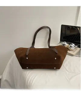Detail of dark brown tote bag base with four silver metal protective rivets for durability