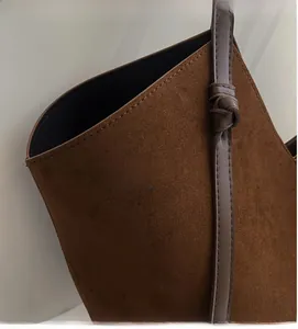Close-up of brown suede tote bag showing soft texture and premium stitching detail