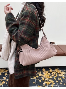 Detail view of pink pleated shoulder bag with functional side pocket and leather texture