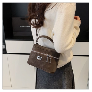 Détail du sac à main marron foncé de style boîte avec texture litchi et bijoux argent